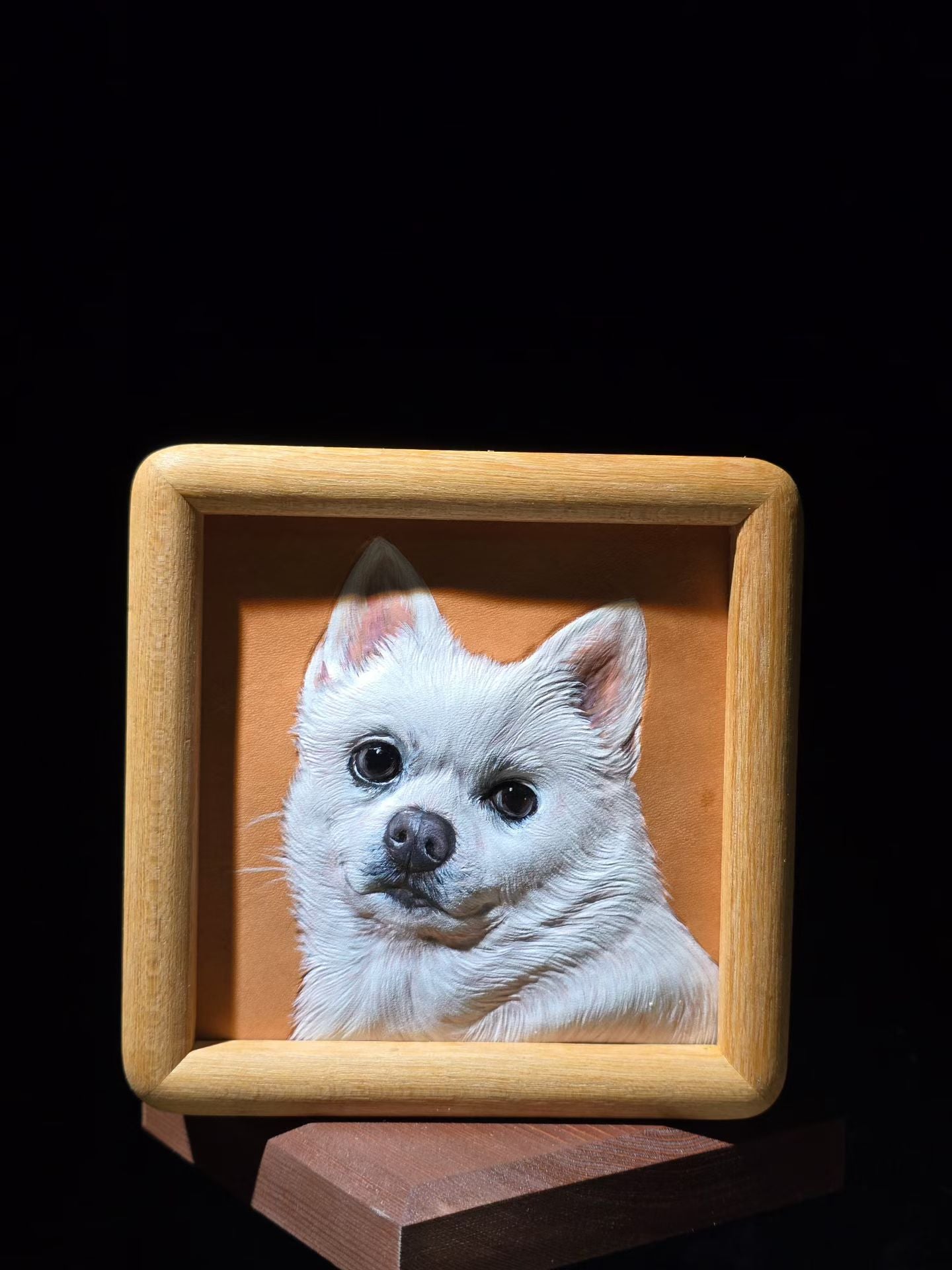 Supplier photograph of a white dog leather portrait in a square wooden frame.