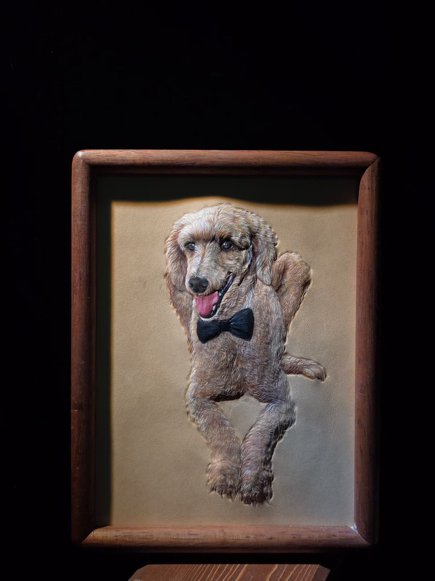 Supplier photograph of a poodle leather portrait in a rectangular wooden frame.
